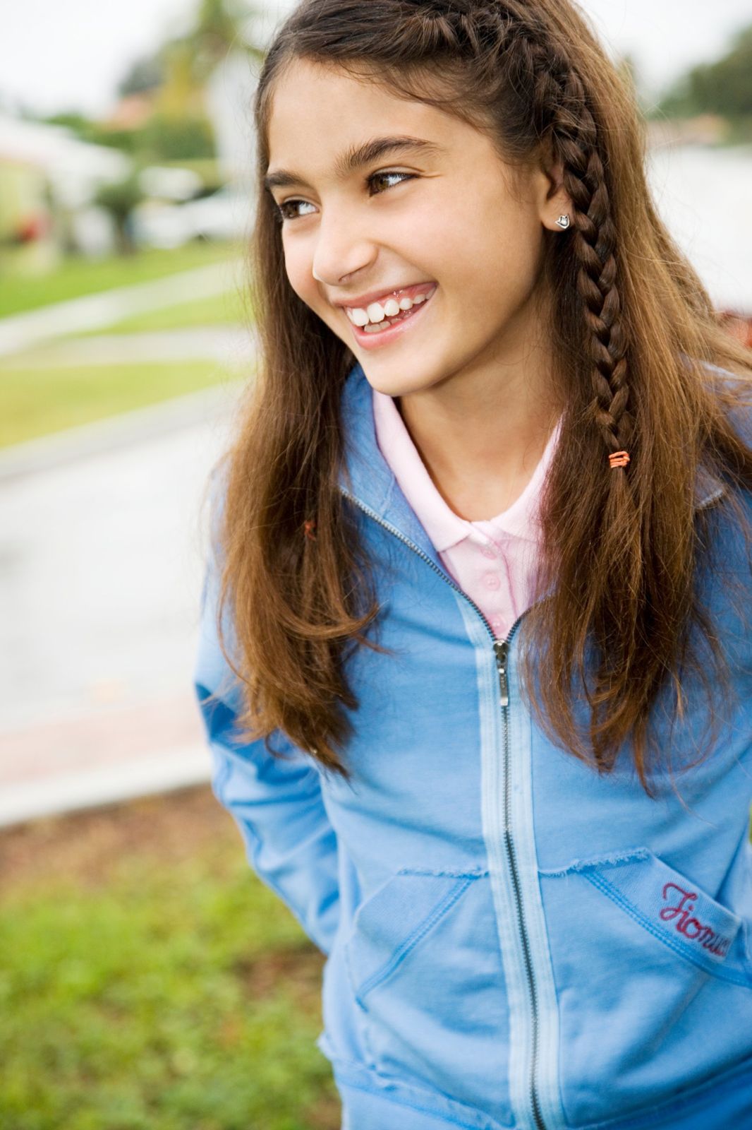 A smiling girl with a braid in a blue jacket